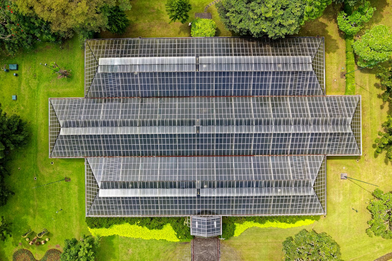 why-choose-us Top-down view of a modern greenhouse surrounded by lush greenery in Indonesia.