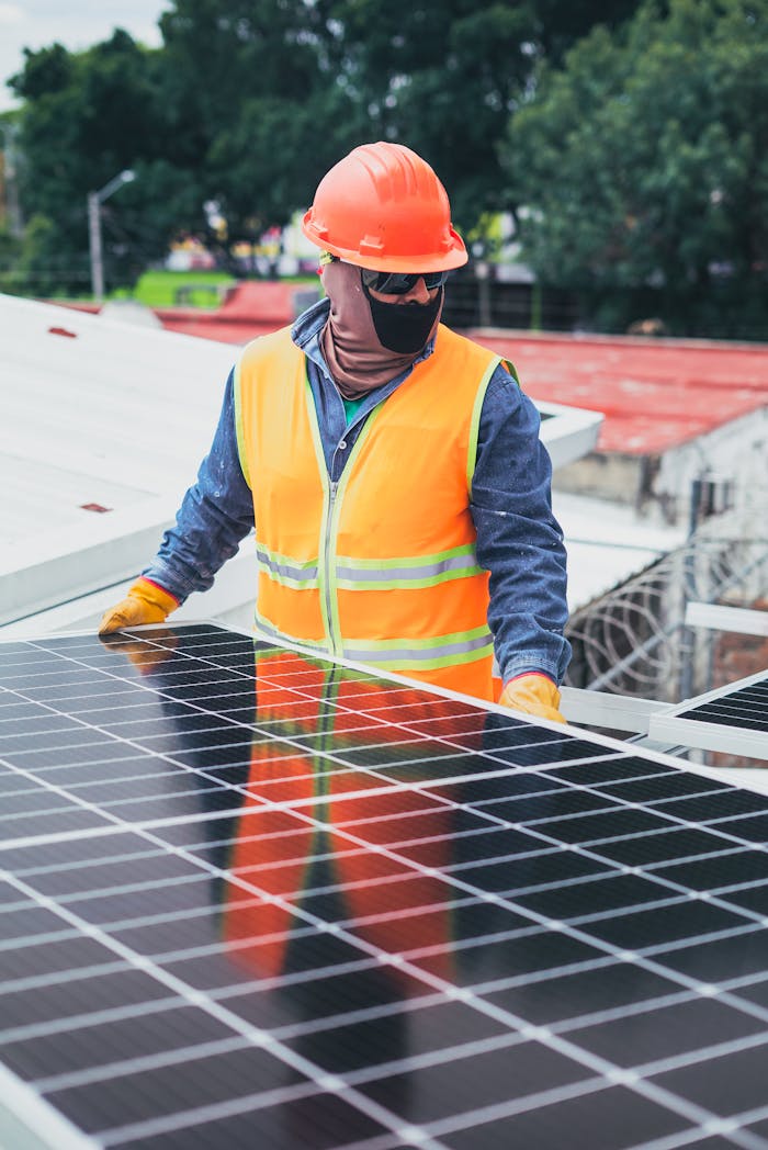 services-01 Technician in protective gear installing solar panels on a sunny day.